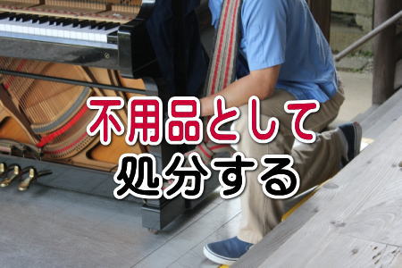 引き取り業者がピアノを運ぶ
